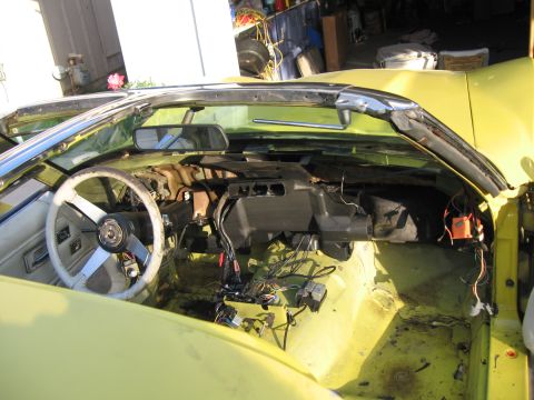 1979 Chevrolet Corvette - The interior of a yellow car is shown with the dashboard disassembled, revealing wiring and components.