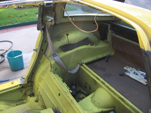 1979 Chevrolet Corvette - The interior of a yellow car is shown with the rear passenger area stripped down for work.