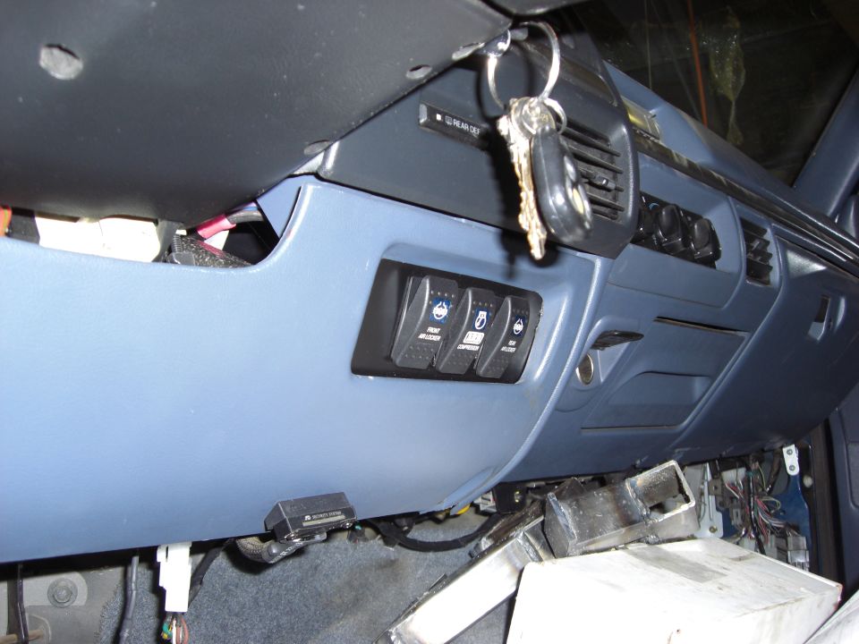 Blue dashboard interior with three auxiliary switches and keys hanging from ignition