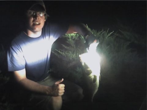 1996 Ford Bronco - Man proudly displays a large fish caught at night.
