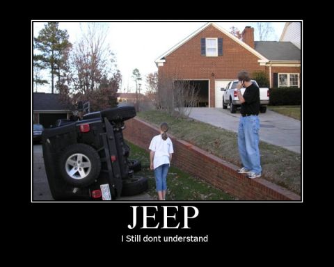 1991 Ford Bronco - A black Jeep Wrangler lies overturned on its side next to a residential street.