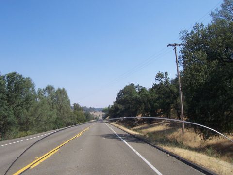 1994 Ford F-150 - A view from a vehicle traveling on a highway through a rural, tree-lined landscape on a clear day.
