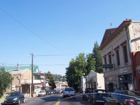 1994 Ford F-150 - A street scene with various vehicles and buildings under a clear blue sky.