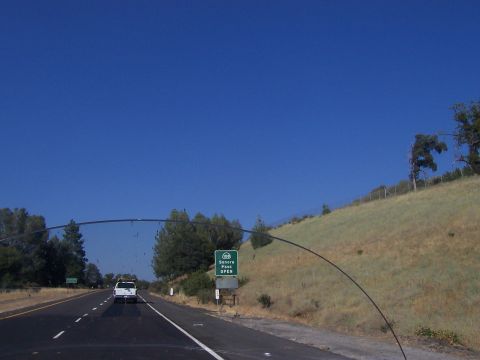 1994 Ford F-150 - A white pickup truck travels down a highway under a clear blue sky, with a sign indicating Sonora Pass is open.