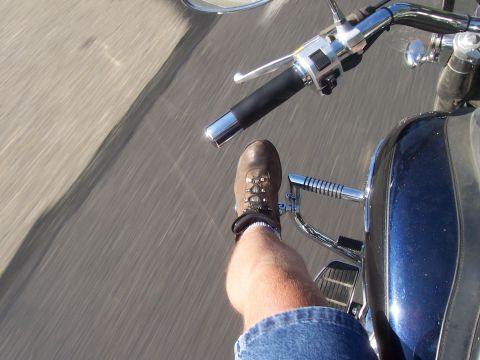 1994 Ford F-150 - View from a motorcycle as the rider's leg and boot are visible, with a blue fairing in the foreground.