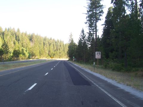 1994 Ford F-150 - A highway passes through a forest, with a speed limit sign indicating 55 mph ahead.