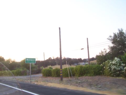 1994 Ford F-150 - Sign for Wallace, California, seen from the roadside with vegetation and utility poles.