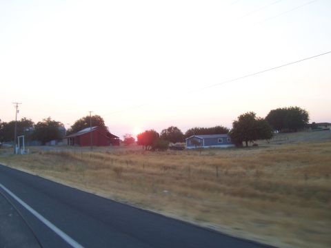 1994 Ford F-150 - A tranquil rural scene unfolds with a red barn and a mobile home bathed in the soft light of a setting sun.