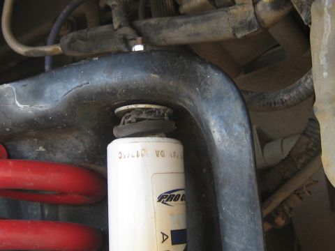 1996 Ford Bronco - A close-up view of a vehicle's suspension system, focusing on a shock absorber and coil spring.