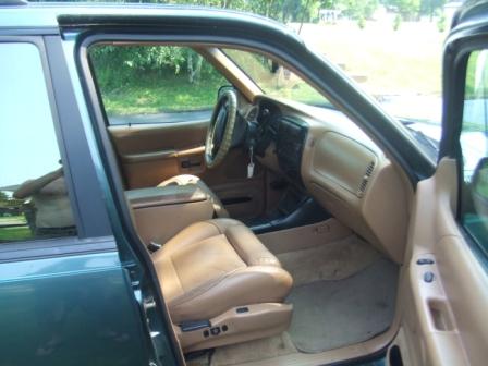 1996 Ford Bronco - Interior view of a green SUV, tan leather seats and dashboard.
