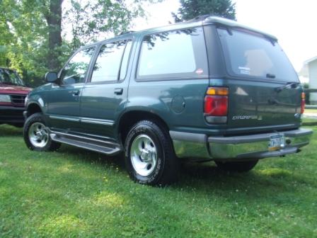 1996 Ford Bronco - Rear 3/4 view of a green Ford Explorer parked on a grassy lawn.