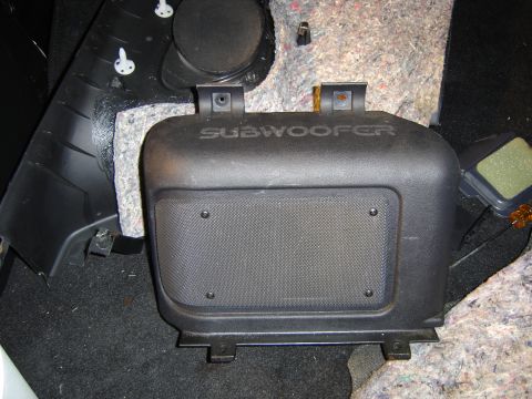 1994 Ford Probe - The interior of a car shows a removed subwoofer housing unit.