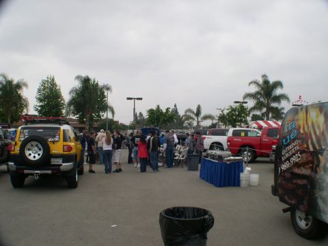 2007 Toyota FJ Cruiser - A yellow 2007 Toyota FJ Cruiser is parked at an outdoor event with other vehicles and people.