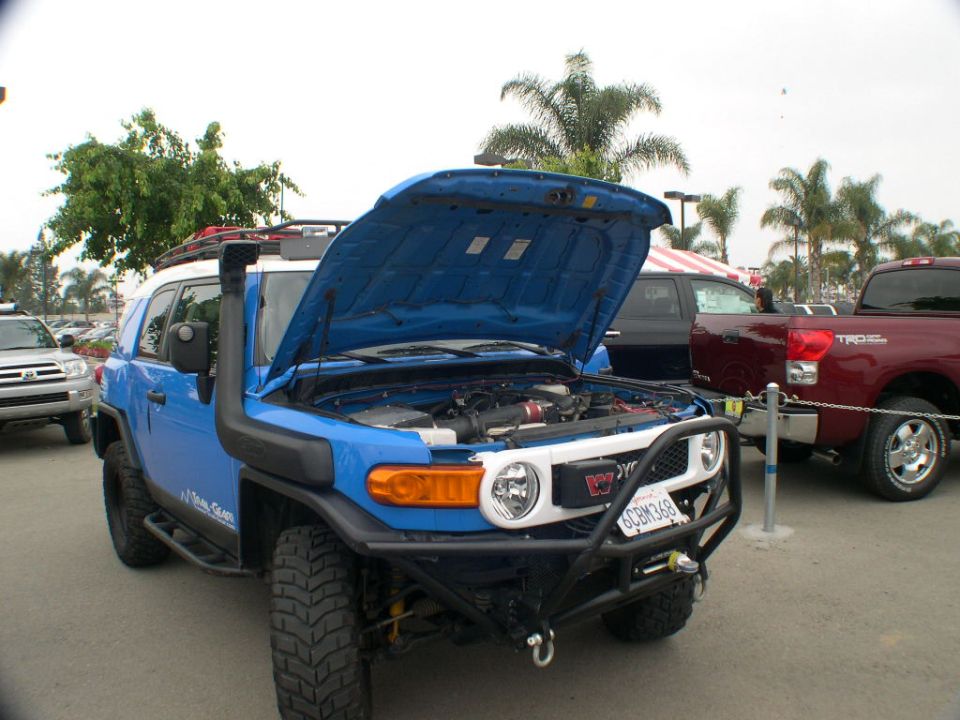 Blue 2007 Toyota FJ Cruiser with hood open, snorkel, and aftermarket bumper