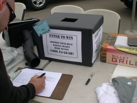 2007 Toyota FJ Cruiser - A raffle box is set up for an event, with a person filling out a clipboard nearby.
