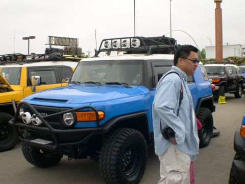 2007 Toyota FJ Cruiser - A man stands next to a blue Toyota FJ Cruiser at an outdoor gathering of similar vehicles.