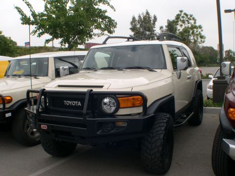 2007 Toyota FJ Cruiser - Two tan Toyota FJ Cruisers parked side-by-side, with the front vehicle prominently displayed.