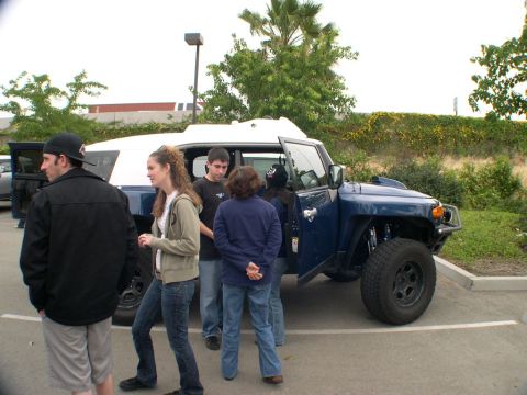 2007 Toyota FJ Cruiser - A group of people stand around a blue 2007 Toyota FJ Cruiser with its doors open.