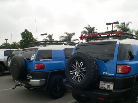 2007 Toyota FJ Cruiser - Multiple Toyota FJ Cruisers are seen parked together in an outdoor lot, with one a Hi-Lift jack on its roof rack.
