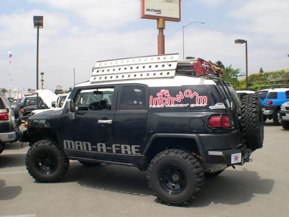 Black Toyota FJ Cruiser with off-road modifications, roof rack, and custom decals.