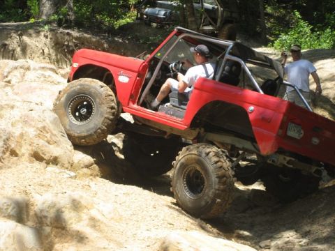 1995 Ford Bronco - This classic SUV is tackling a challenging off-road course with steep inclines and large rocks.