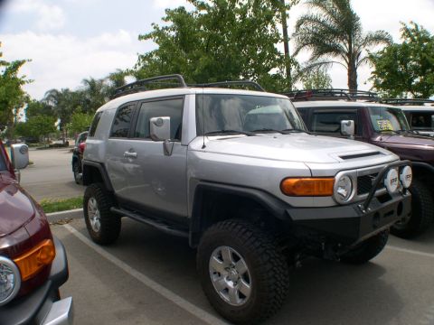 2007 Toyota FJ Cruiser - A silver Toyota FJ Cruiser is parked in a lot, with other vehicles nearby. The front of the vehicle is visible.