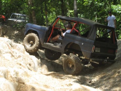 1995 Ford Bronco - Ford Bronco tackling a challenging off-road course with a second vehicle in the background.