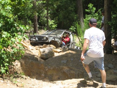 1995 Ford Bronco - An off-road vehicle navigates a challenging rocky course, with a driver visible inside.