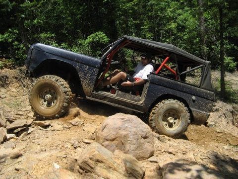 1995 Ford Bronco - A driver maneuvers an off-road vehicle through a challenging, rocky landscape.