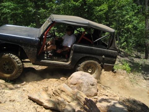 1995 Ford Bronco - A black 1978 Ford Bronco navigates a rocky trail with a driver at the wheel.