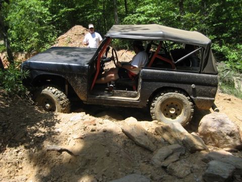 1995 Ford Bronco - A classic Ford Bronco tackles a challenging off-road trail, demonstrating its capabilities.