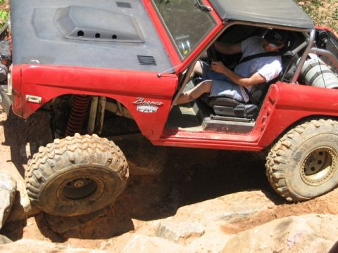 1995 Ford Bronco - A red 1978 Ford Bronco navigates a rocky trail with its driver behind the wheel.