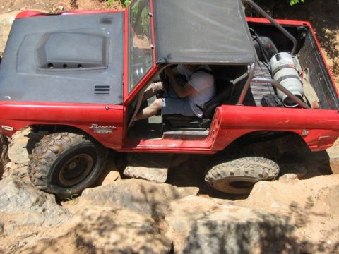 1995 Ford Bronco - This Bronco is navigating a rocky trail with its doors removed and a roll cage installed.