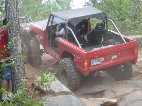 1995 Ford Bronco - This red SUV is navigating a rocky trail with another vehicle following closely behind.