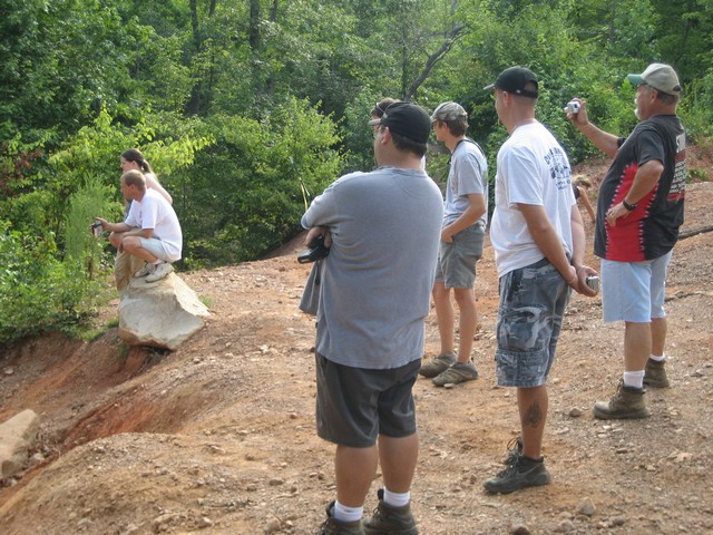 People watch off-roading activity on a dirt path