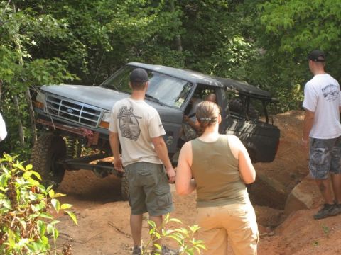 1995 Ford Bronco - A 1995 Ford Bronco navigates a challenging off-road course with onlookers present.