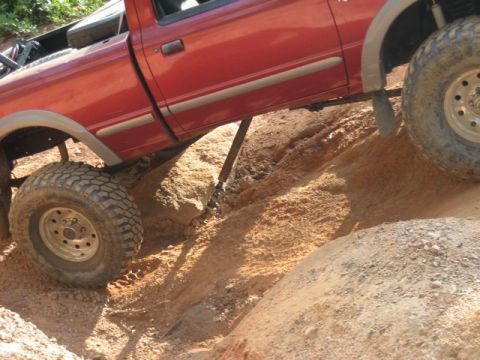 1995 Ford Bronco - Pickup truck attempting to climb a steep, rocky terrain.