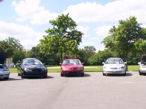 1998 Ford Taurus - A trio of Ford Tauruses are lined up in a parking lot on a sunny day.