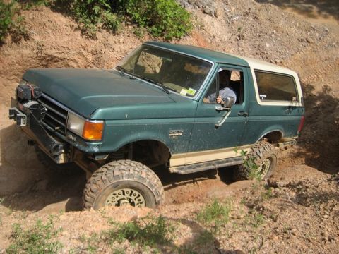1995 Ford Bronco - 1995 Ford Bronco tackling a challenging off-road course.