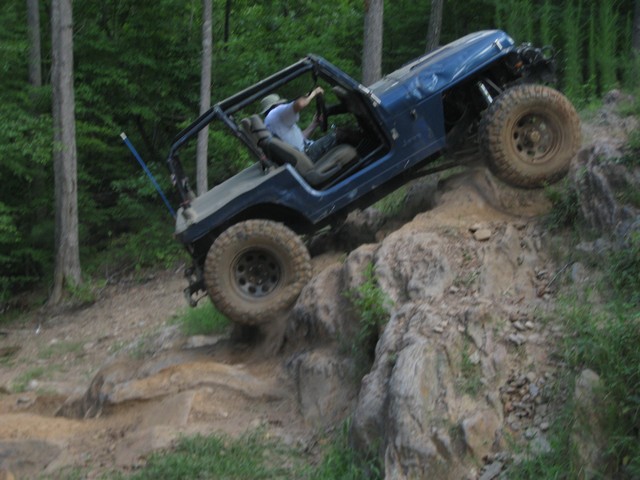Blue off-road jeep climbing rocky terrain