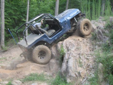 1995 Ford Bronco - Off-road vehicle navigates a challenging rocky terrain during an outdoor excursion.