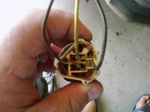 1986 Ford Bronco - A hand holds a fuel sending unit, a component of a vehicle's fuel system.