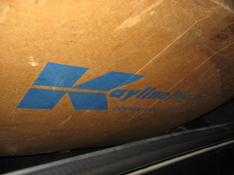 1989 Ford Bronco - Close-up of a scuffed cardboard shipping box printed with the blue Kayline Mfg. Inc. logo and "Denver, Colorado" text, resting inside a veh…