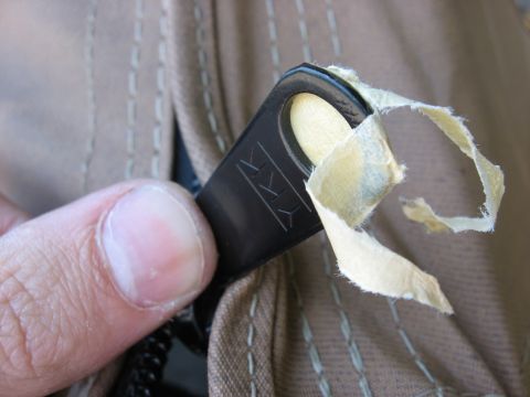1989 Ford Bronco - Close-up of a zipper pull tab with the YKK logo, showing torn tape attached.
