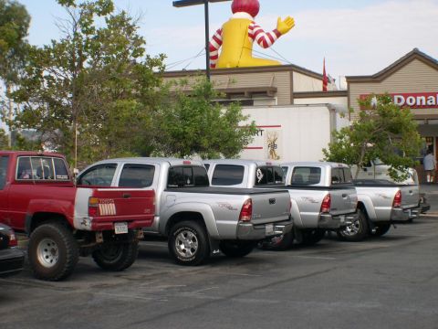 2007 Toyota FJ Cruiser - Multiple Toyota pickup trucks are parked outside a McDonald's, with a large Ronald McDonald inflatable overhead.