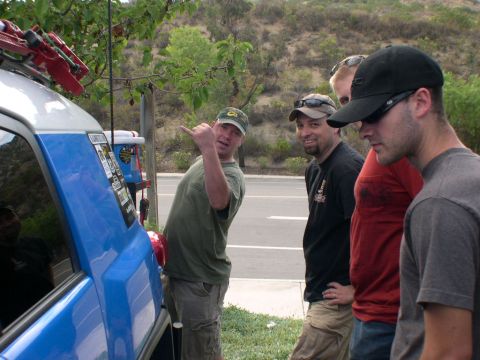 2007 Toyota FJ Cruiser - A group of men stand around a blue 2007 Toyota FJ Cruiser, which is equipped with a roof rack and various stickers.