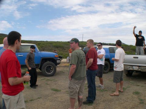 2007 Toyota FJ Cruiser - Group gathered around a blue Toyota FJ Cruiser and a silver pickup truck on a sunny day.
