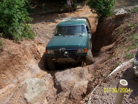 1979 Ford F-150 - Off-roading adventure in a green 4x4 truck on a challenging dirt path.