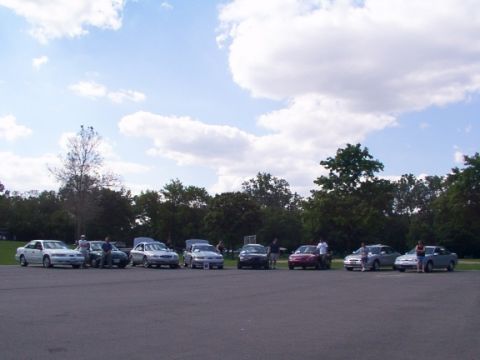 1998 Ford Taurus - Several sedans, including a 1998 Ford Taurus, are parked in a lot during a TCCA meet.