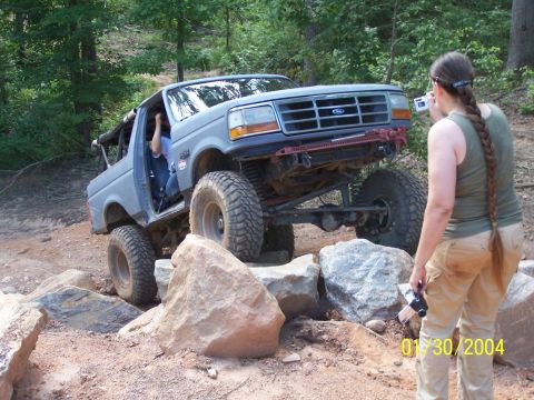 1979 Ford F-150 - A modified truck navigates a rocky obstacle course on a wooded trail.
